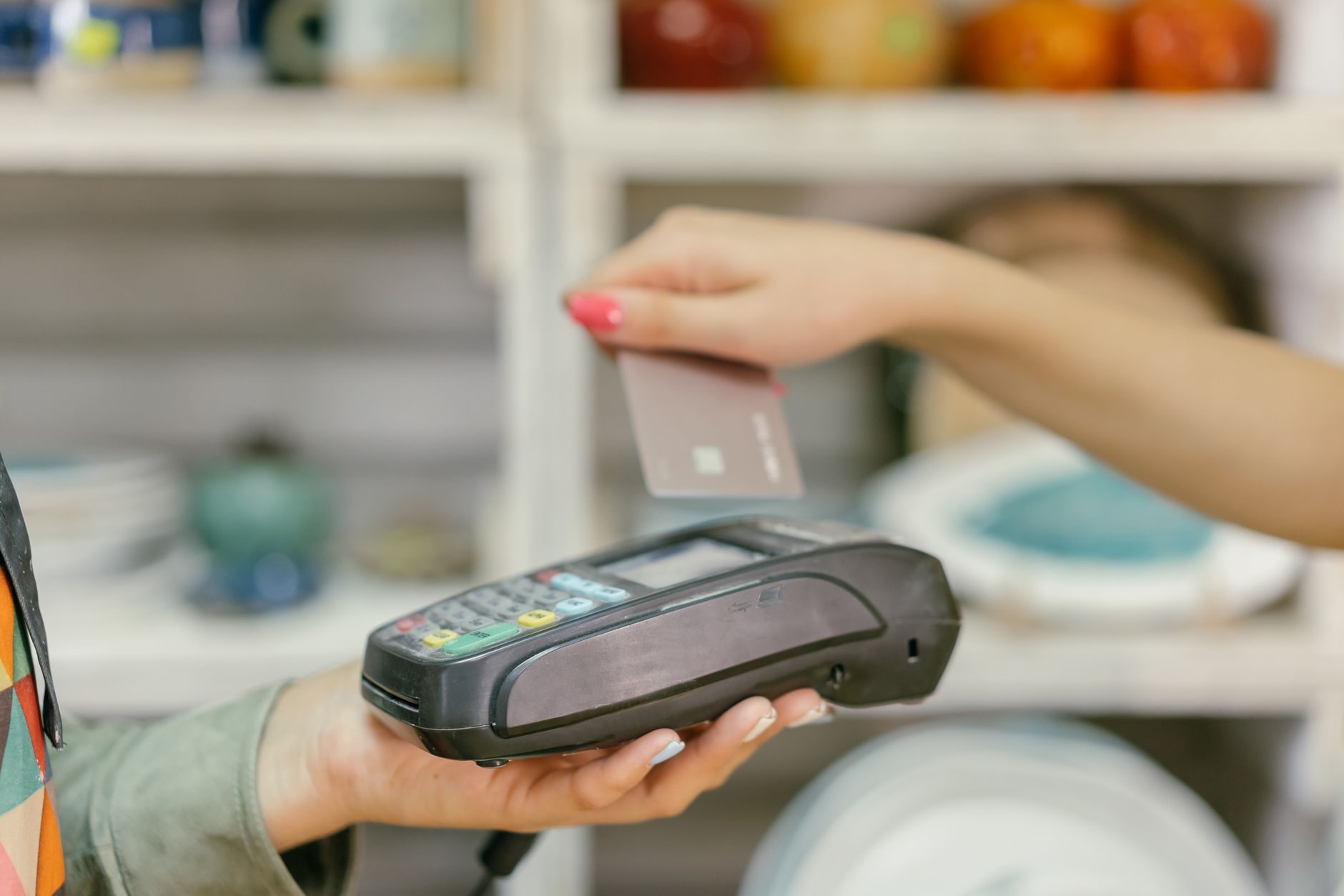 Terminal de paiement sans contact dans une boutique, carte bancaire approchée