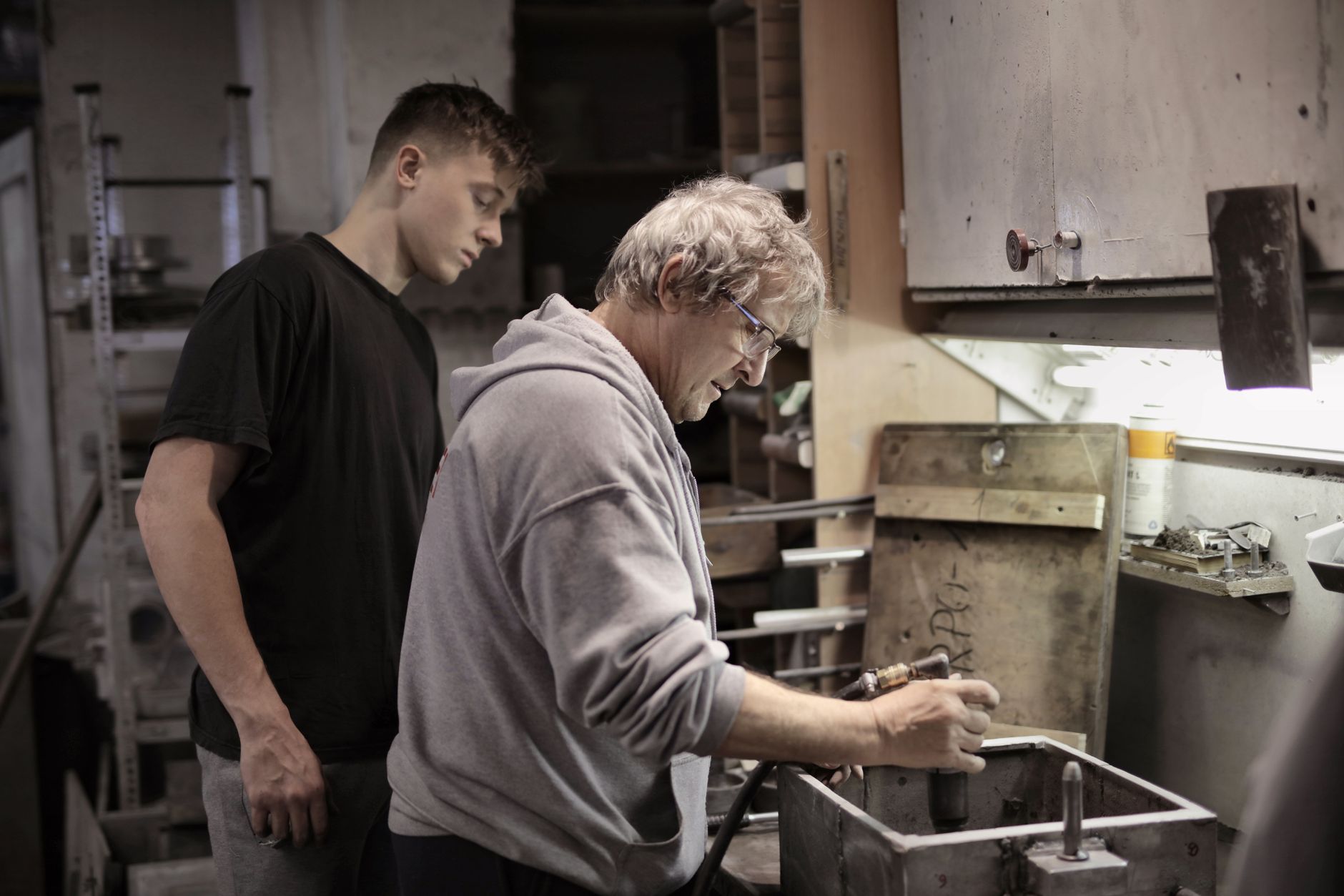 Un artisan expérimenté transmet son savoir-faire à un jeune apprenti dans son atelier
