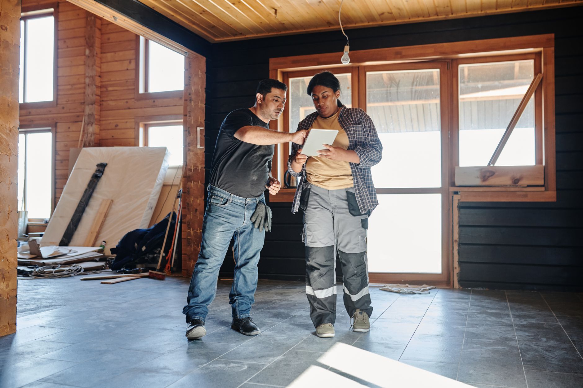 Deux artisans font le point sur une tablette dans une maison en fin de chantier